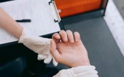 Close-up of a medic checking a patient's pulse wearing gloves.